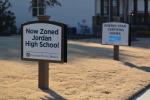 A new housing development promotes recent zoning changes for districted high school.