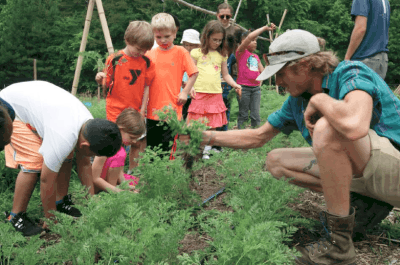 Kids from Durham’s E.K. Powe Elementary School learn about carrots at Durham Public Schools’ Hub Farm. (Photo courtesy Hub Farm Facebook page.)