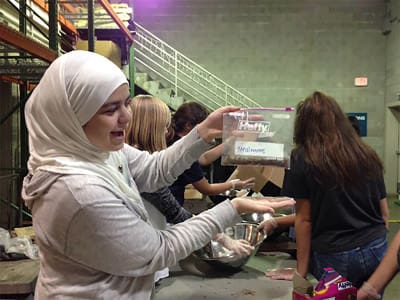 Sarah Asfari holds up mealworms during her service work at the North Carolina Museum of Natural Science. 