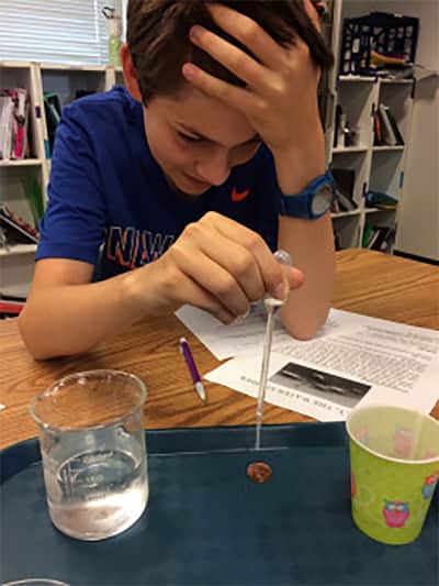 Henry Long working on an experiment to find the best materials for filtering water.
