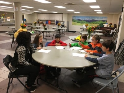 A group of 4th and 5th graders interview Soteria Shepperson of The Shepherd’s Table Food Kitchen (Credit: Lana Hamad)