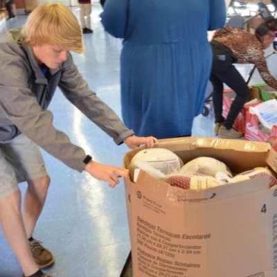 Skyler Hodge, student president of West Edgecombe Middle School, drags a box of donated turkeys (Photo Credit: Alex Granados)