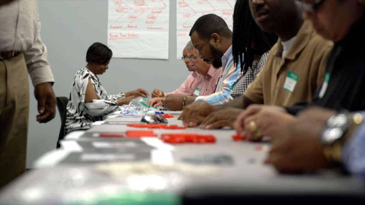 Students in a classroom work on an assembly line