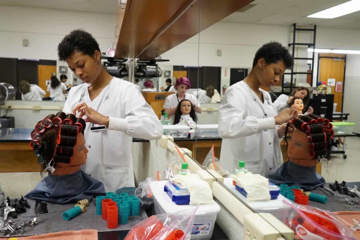 Students curl hair on mannequins