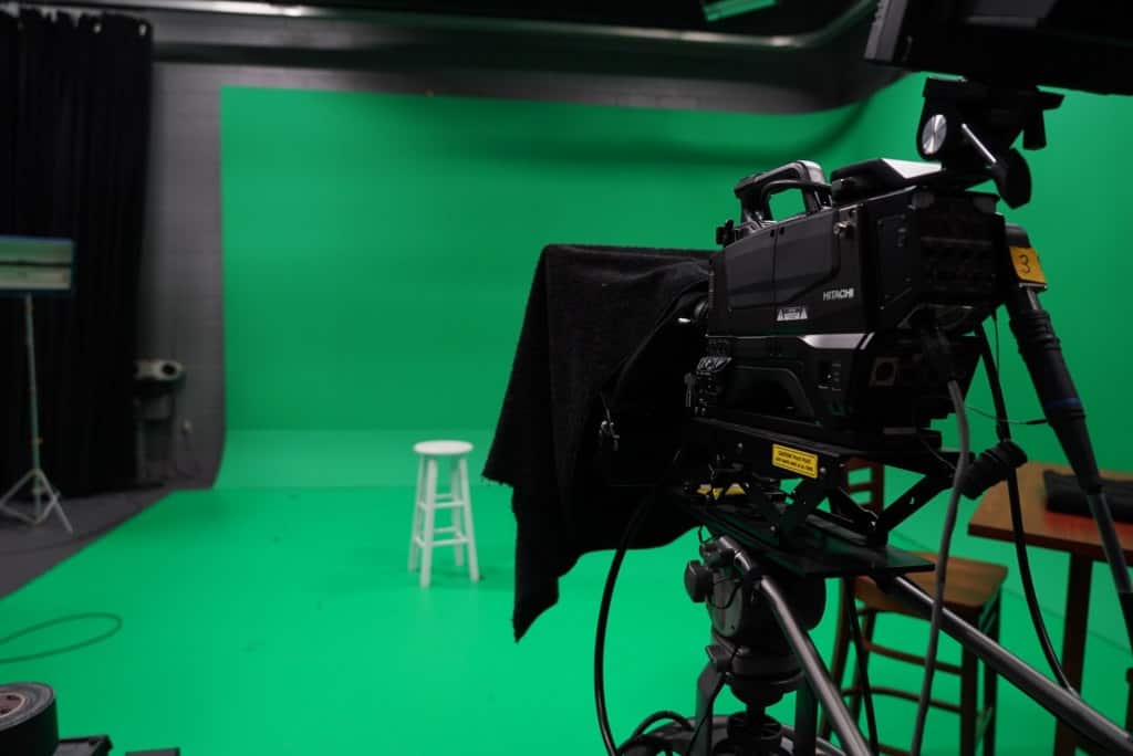 A camera in front of a green screen