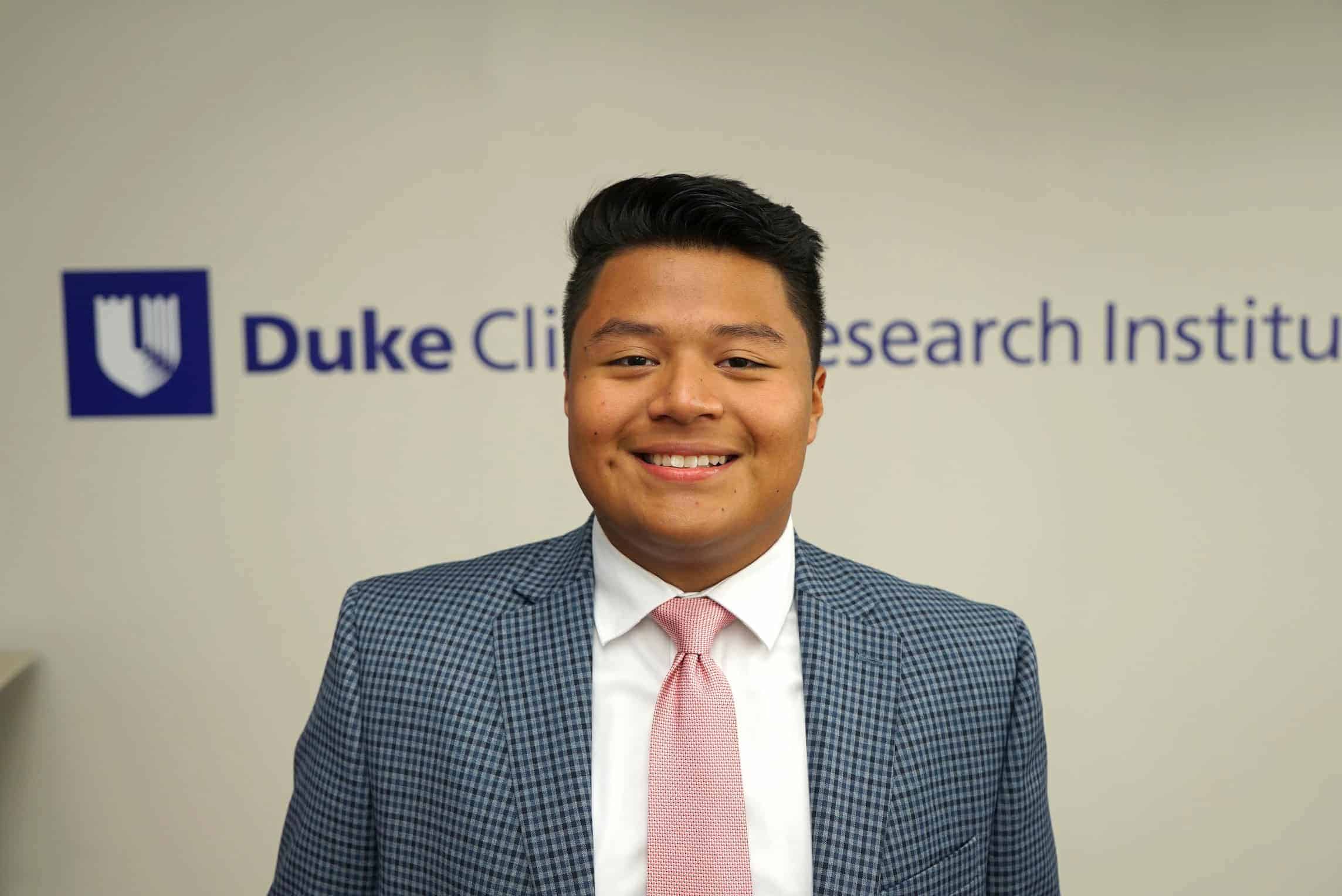 Isaias stands in front of Duke signage