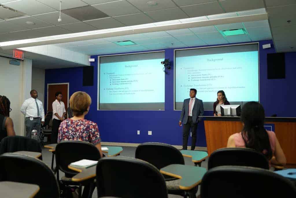 Students giving a presentation in front of projector screens