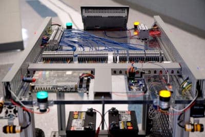A four-wheeled cart with many circuit boards and wires
