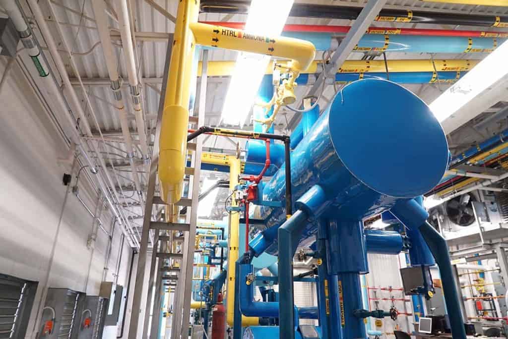 A huge blue tank with yellow pipes stretches to the ceiling
