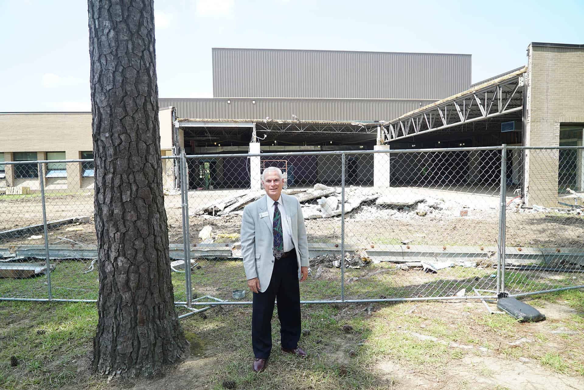 President Johnson stands in front of construction rubble