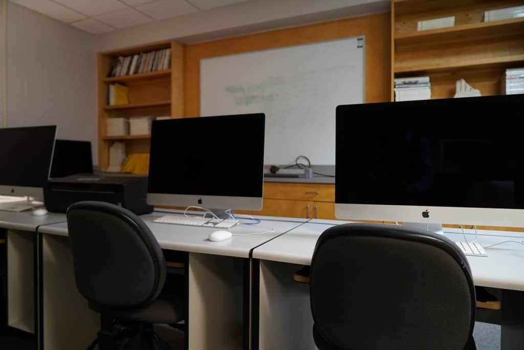 a classroom with iMacs and whiteboard