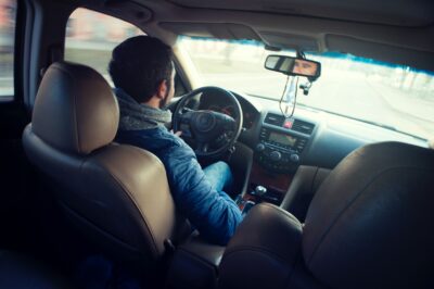 backseat view of a man driving a car a