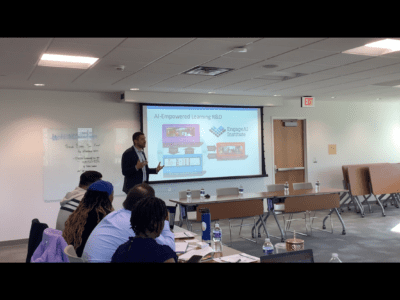 man presents in front of projector screen in class