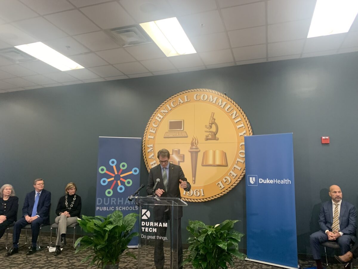 Man stands at podium in front of panel