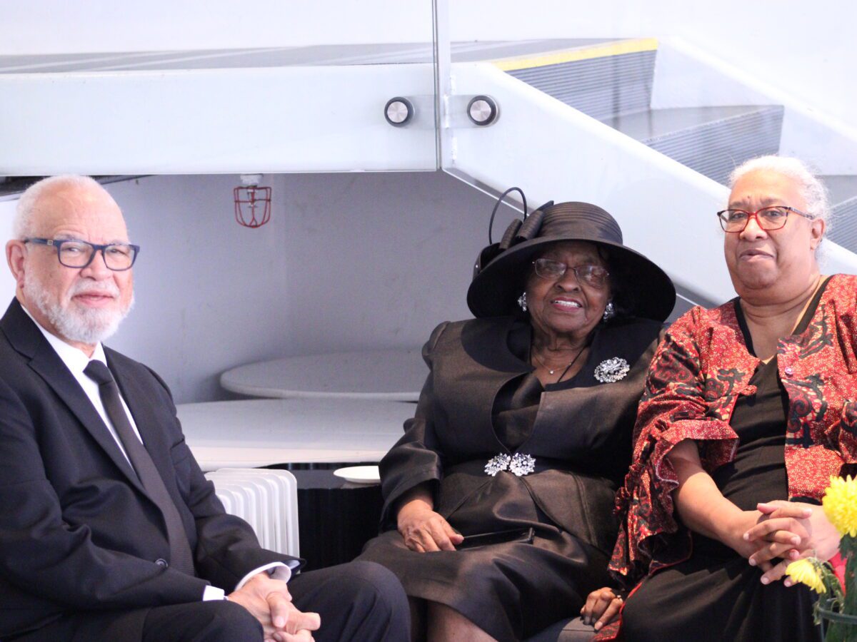 three people posing for picture on a couch