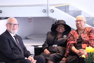 three people posing for picture on a couch