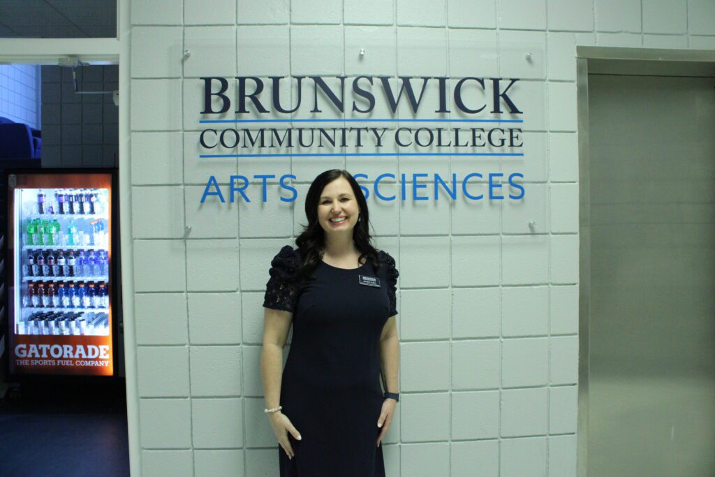 woman standing in front of Brunswick Community College Arts and Science sign