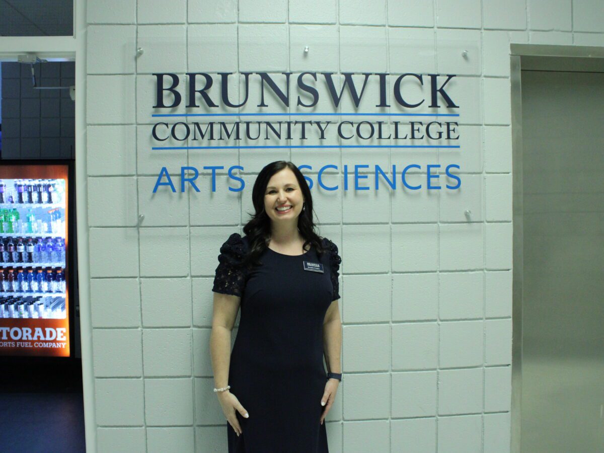 woman standing in front of Brunswick Community College Arts and Science sign