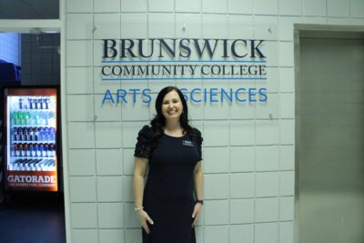 woman standing in front of Brunswick Community College Arts and Science sign