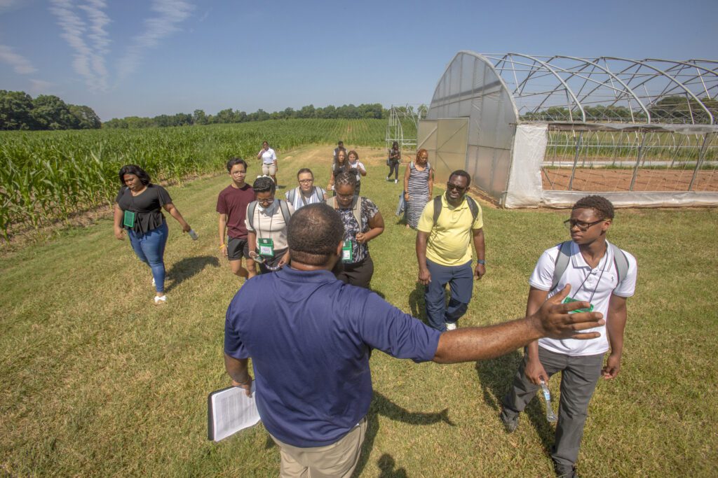 man standing in field leading a group