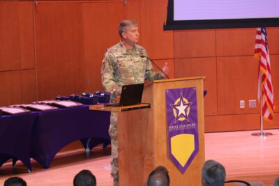 man in army camouflage at podium