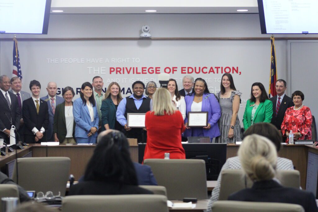 people standing in large group holding certificates