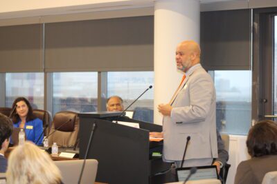 man speaking in boardroom at podium
