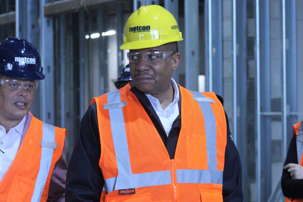 man with an orange vest and yellow construction hat on