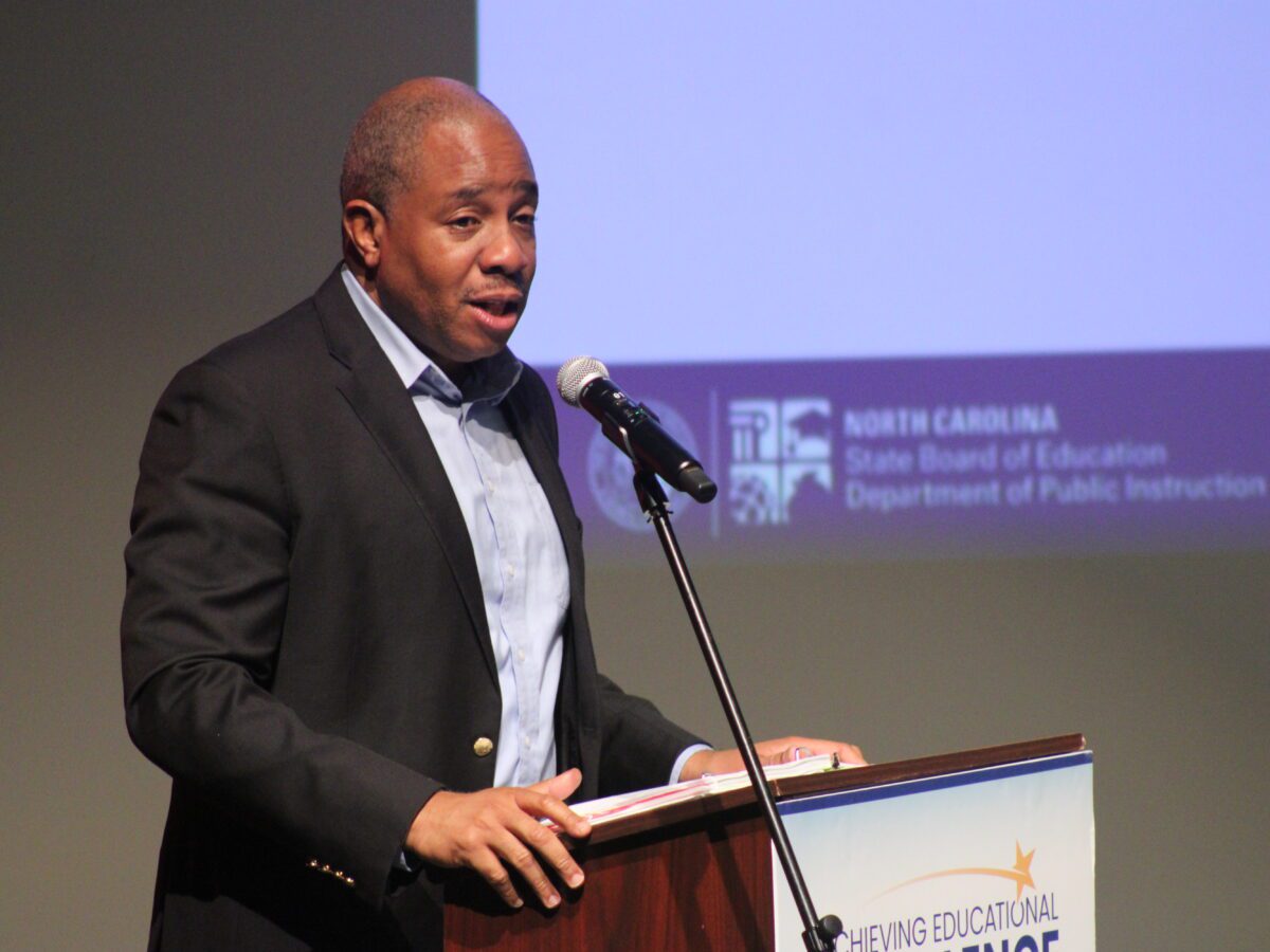 man standing at a podium leaning into a mic