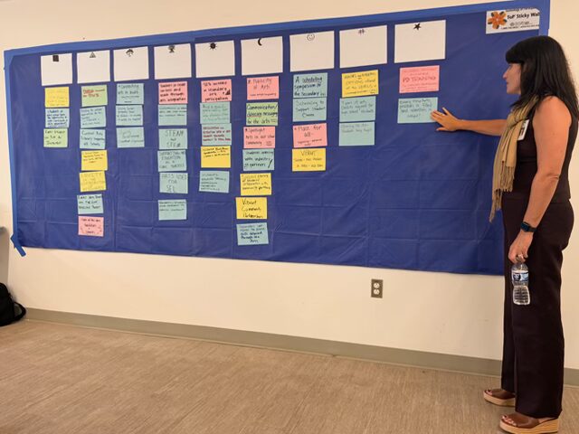 woman in front of a board of colorful index cards