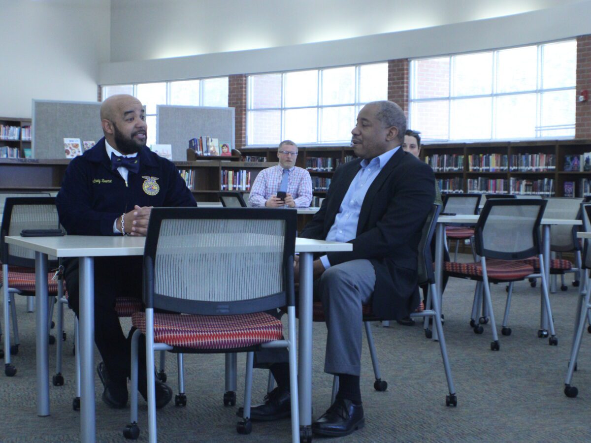 two men sitting at a table in a library