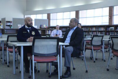 two men sitting at a table in a library