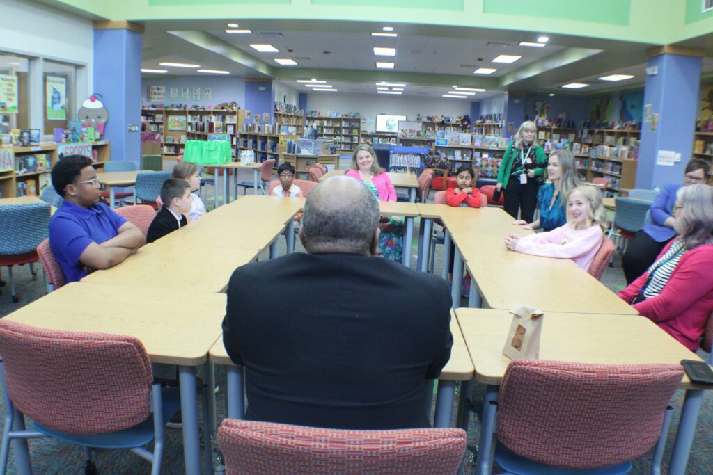 mo green sitting at the end of a boardroom table