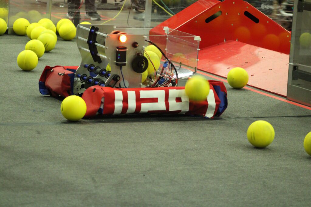 robot surrounded by large green tennis balls with the number 11297 on it