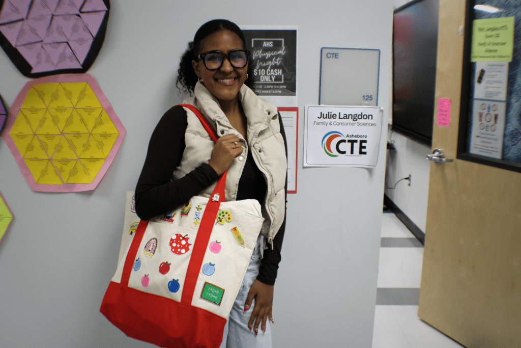 girl holding bag in front of a classroom