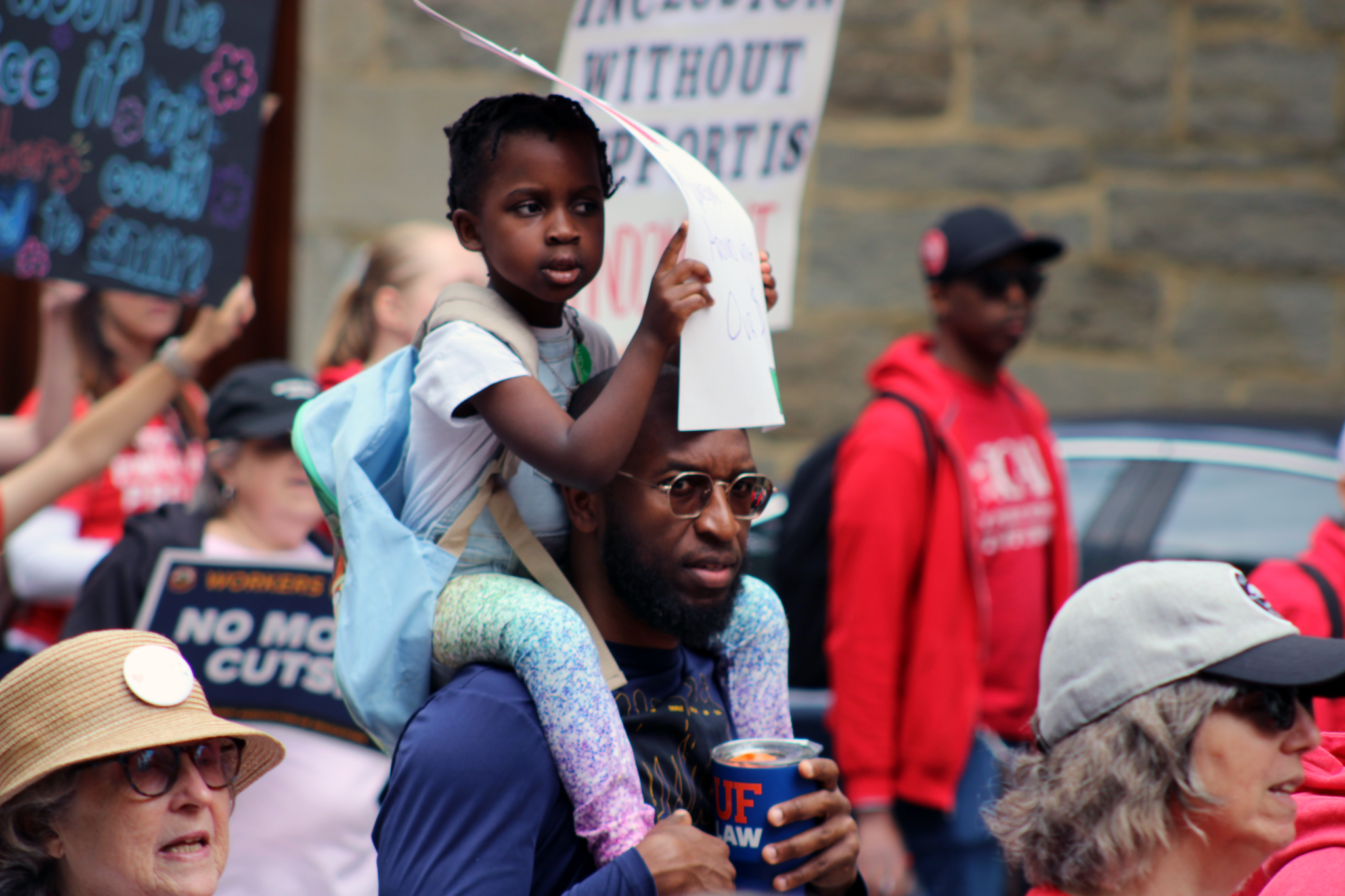 man holding small child on shoulders