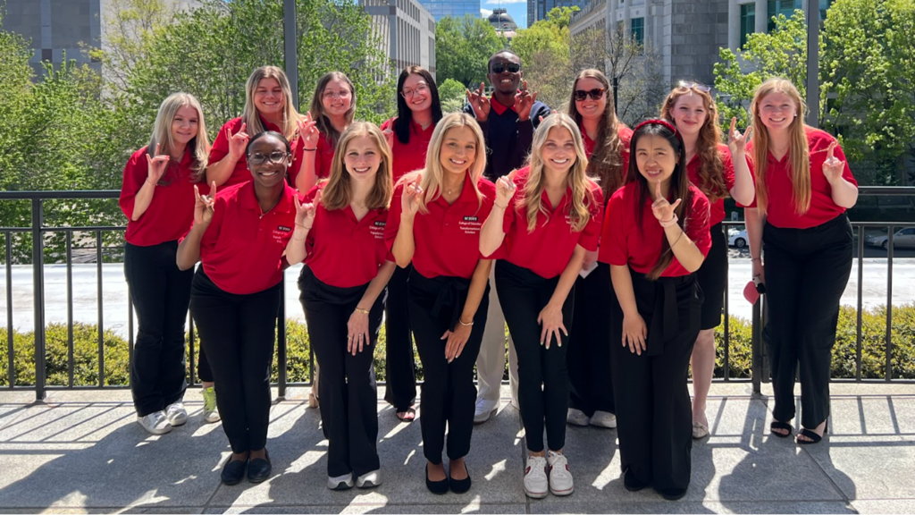 students posing while making a wolf with their hands