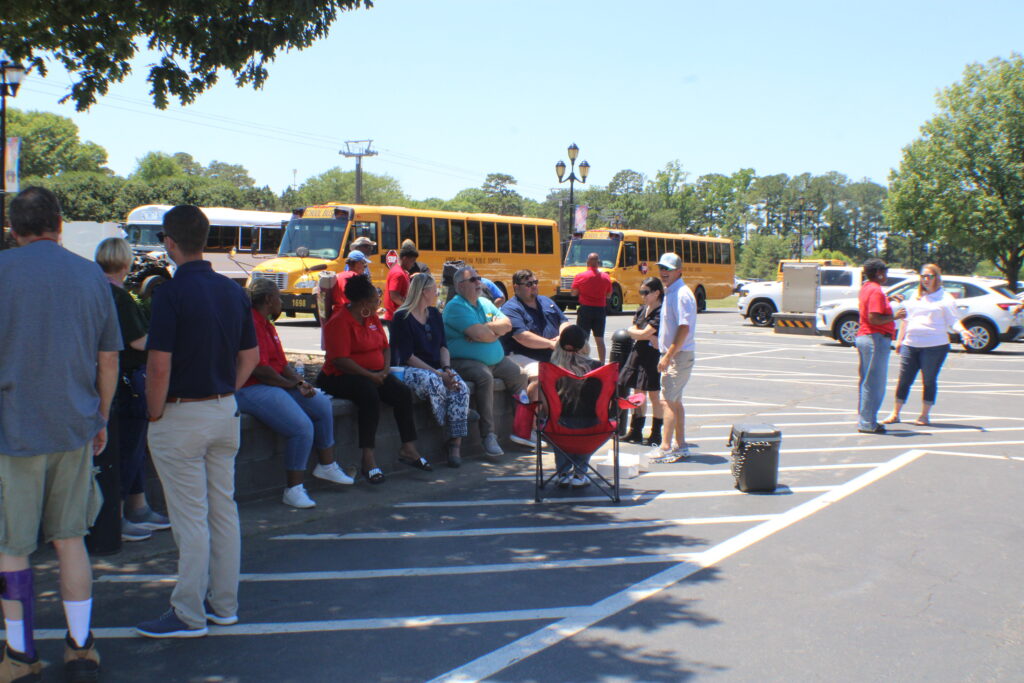 people sitting in front of school buses.