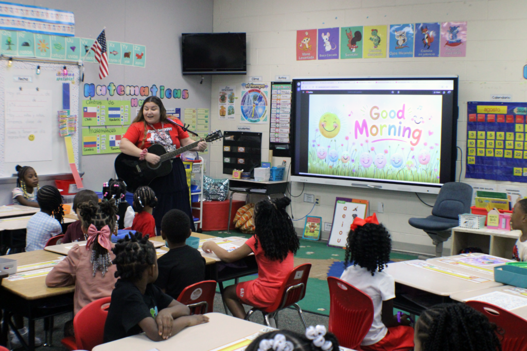 woman singing in classroom with guitar