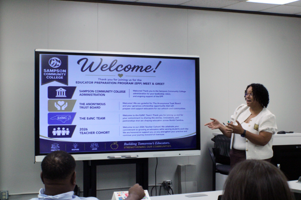 woman standing in front of a powerpoint on a boxed screen similar to a SmartBoard