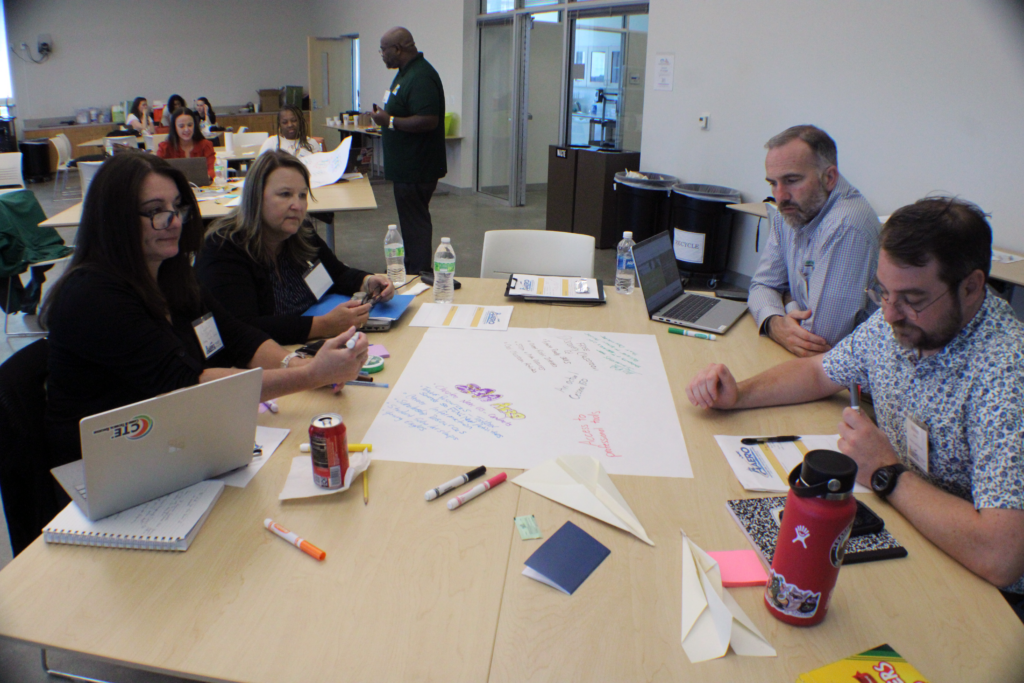 people sitting around a table with chart paper