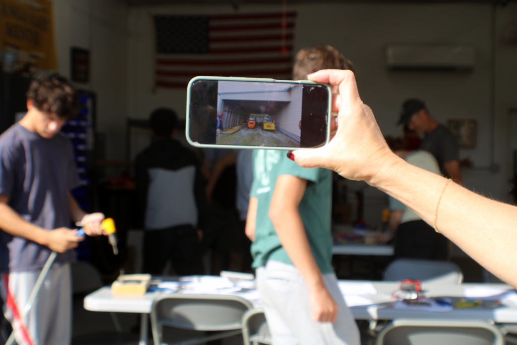 woman holding image on a phone against the same location in the background
