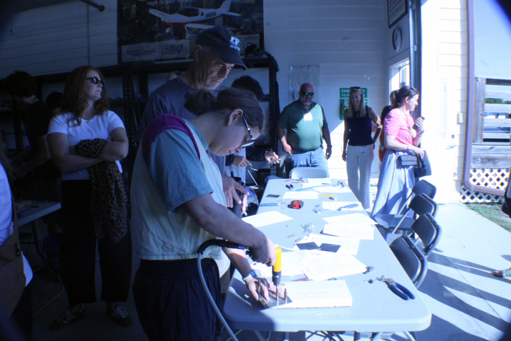 people looking at tools and instructions on a table