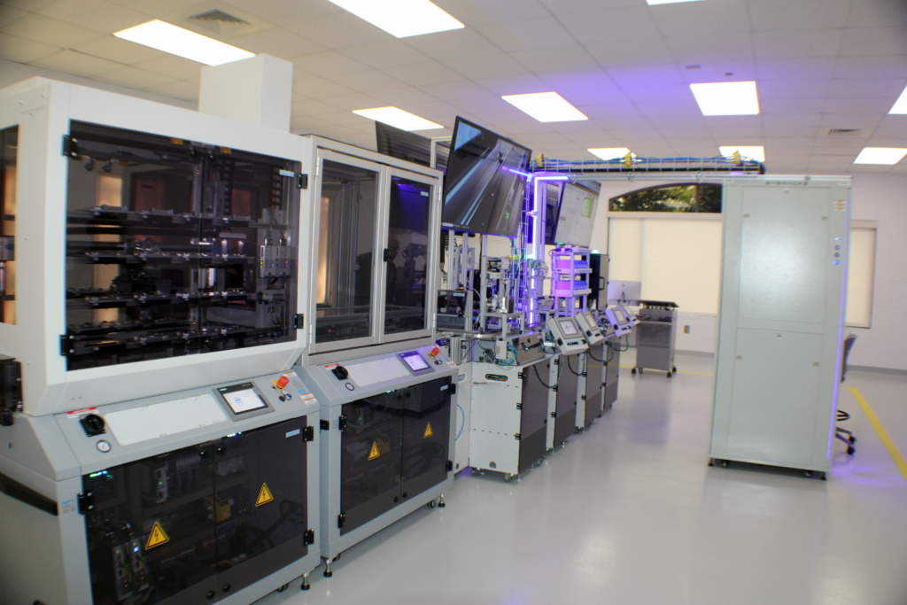 machines in white boxes in a long room